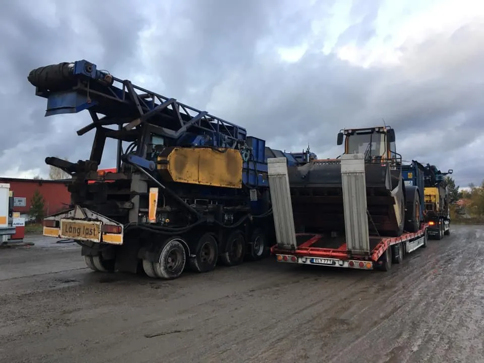 Två maskiner lastade på trailers för transport